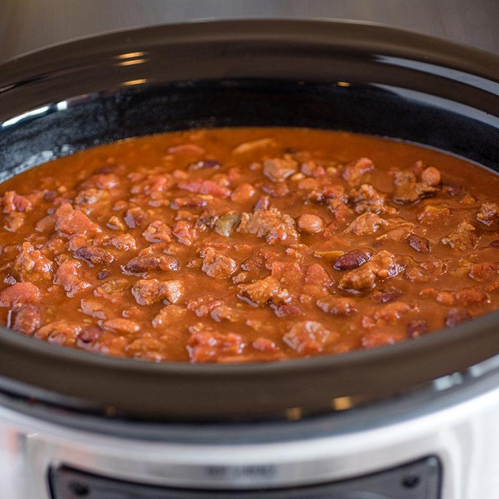 Vintage kitchen with a grandmother slow cooking beef chili