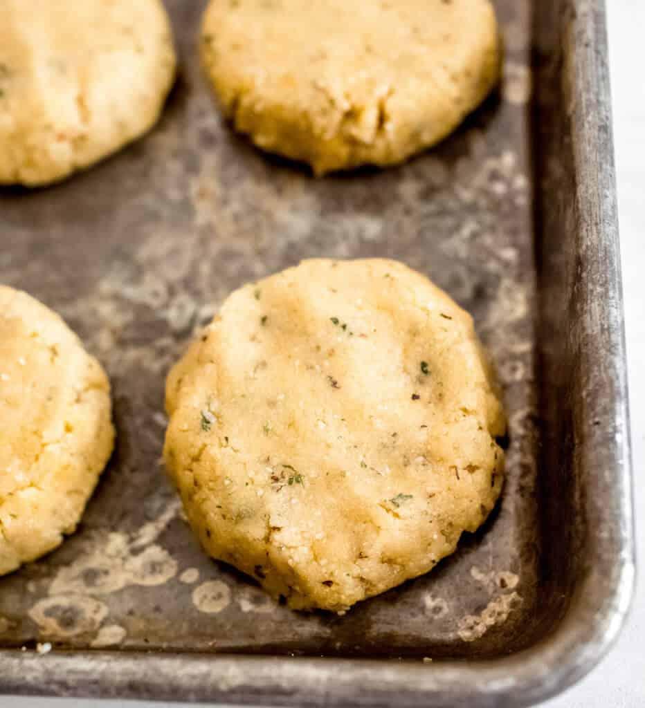close up shot of golden brown garlic herb keto cheese wafers on a baking sheet