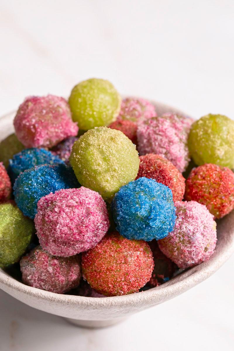 Close-up of a Sour Patch Kid candy being dropped onto brownie batter