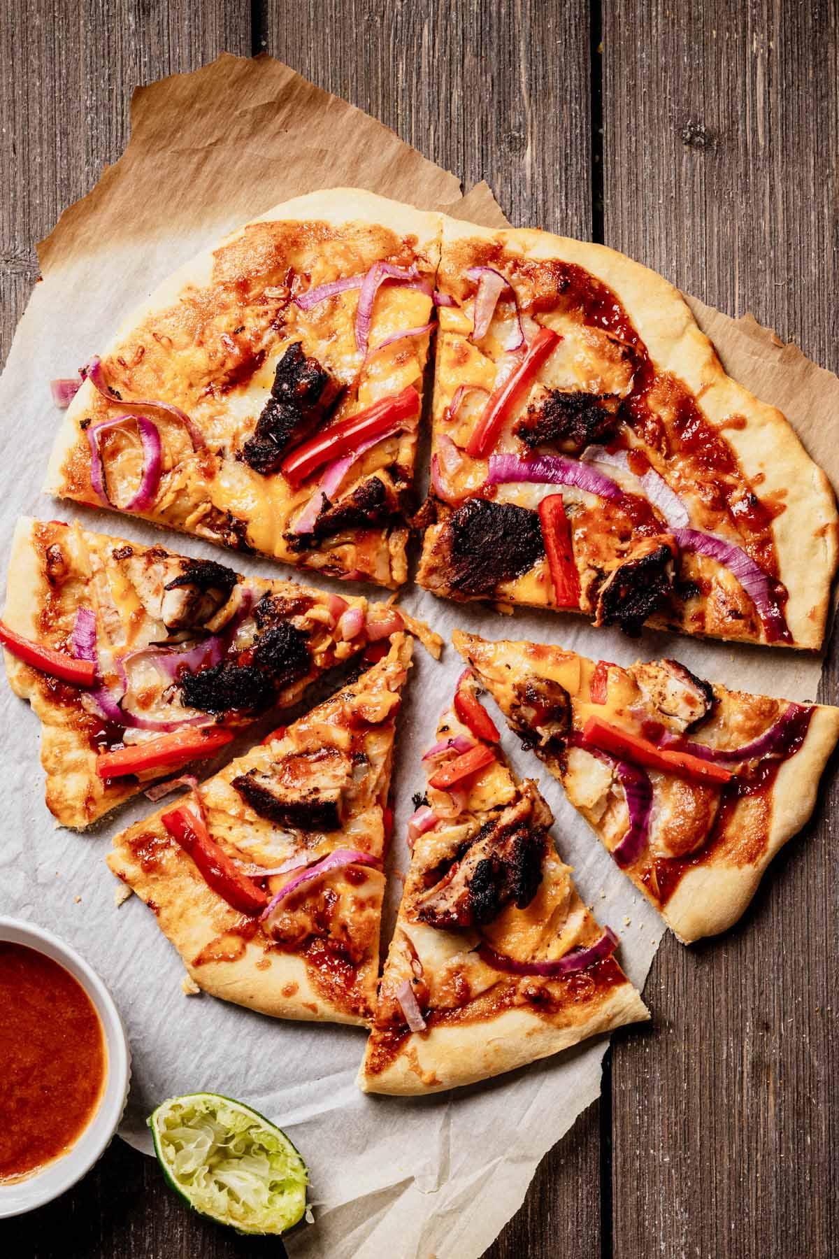 Slices of spicy jerk chicken pizza being served
