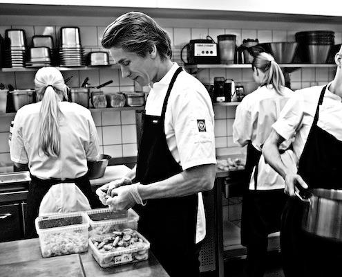 chef preparing smørrebrød in a restaurant kitchen