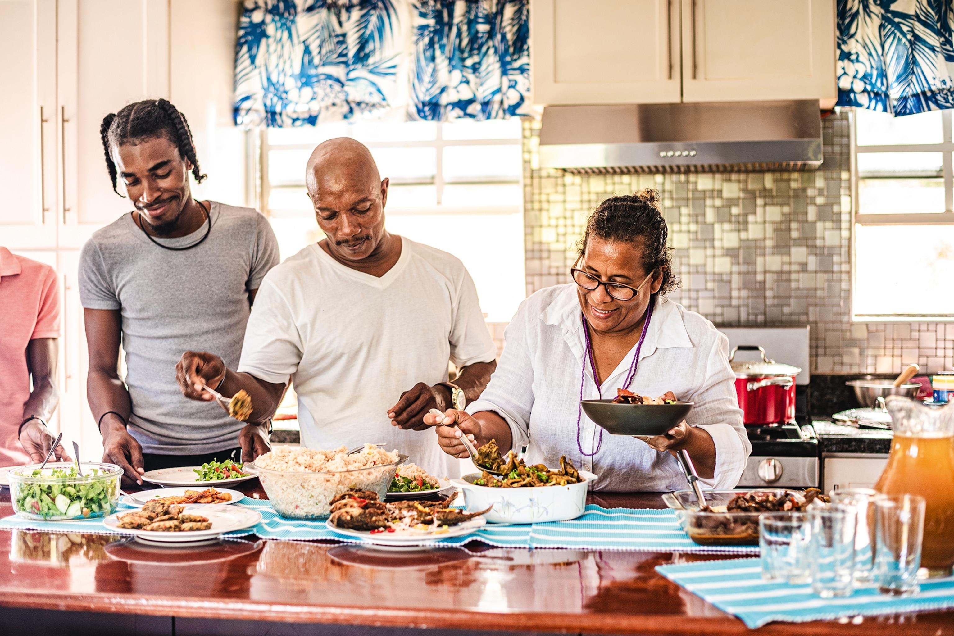 a family enjoying a meal together, with a bowl of steamed rice with chives and parsley on the table