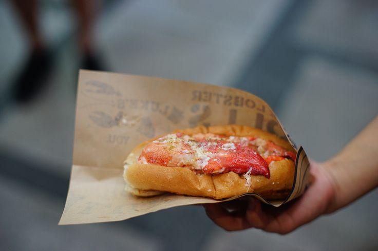 A person holding a lobster roll wrap