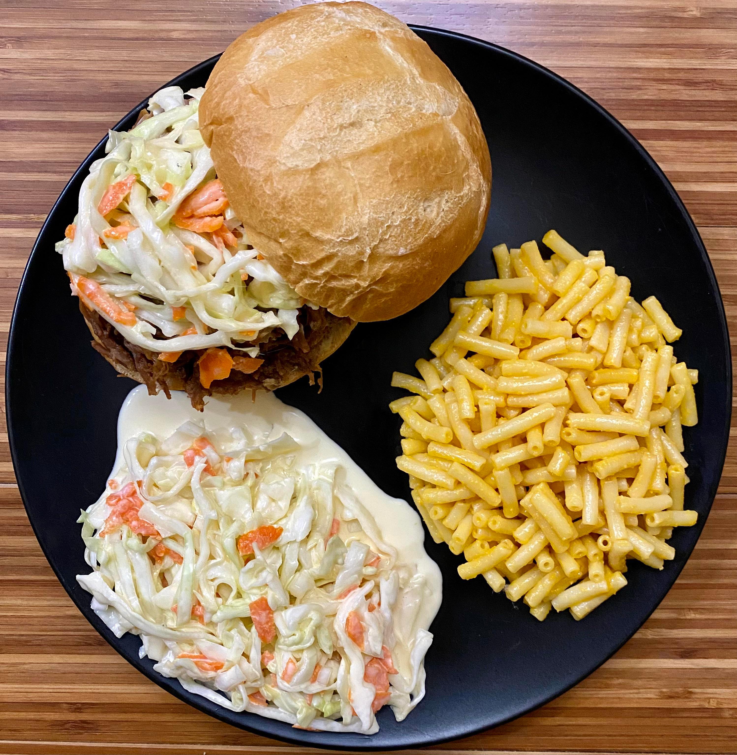 A visually appealing close-up shot of Pulled Pork Mac and Cheese with Coleslaw, showing the texture and colors of each component.
