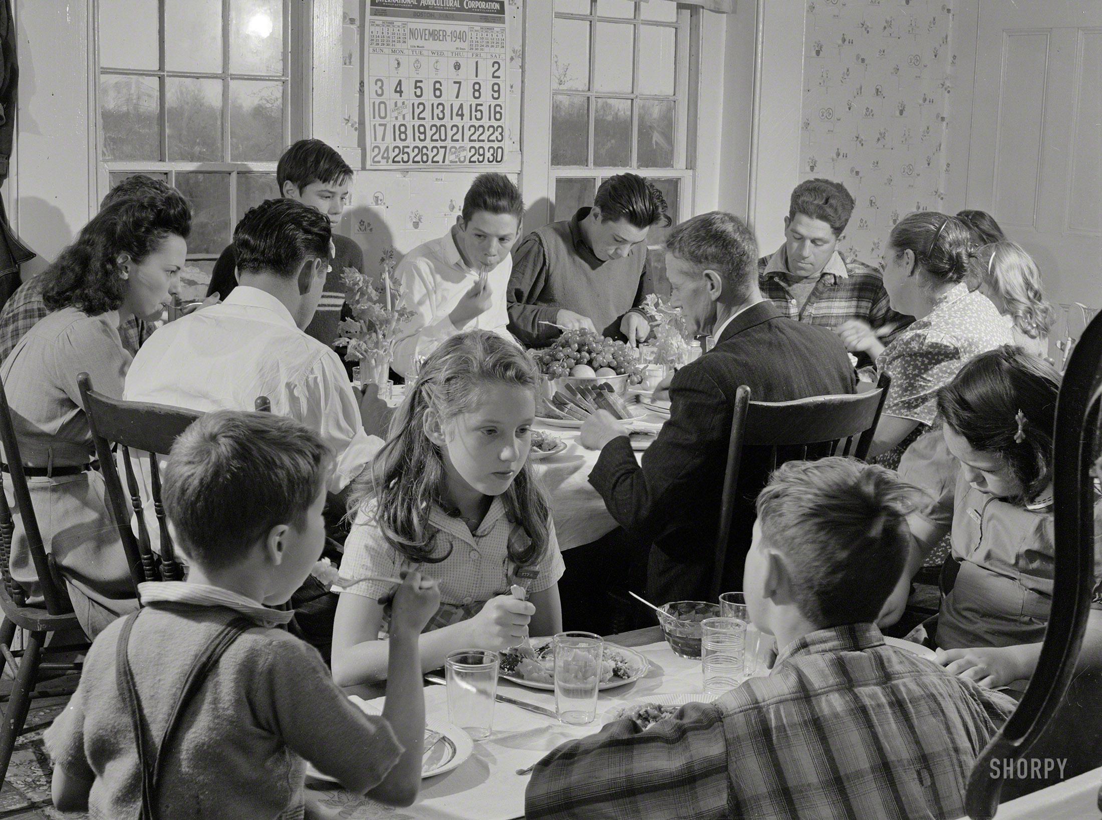 vintage photo of a family gathered around a holiday table with corn casserole, warm lighting, focus on a child's hand reaching for it