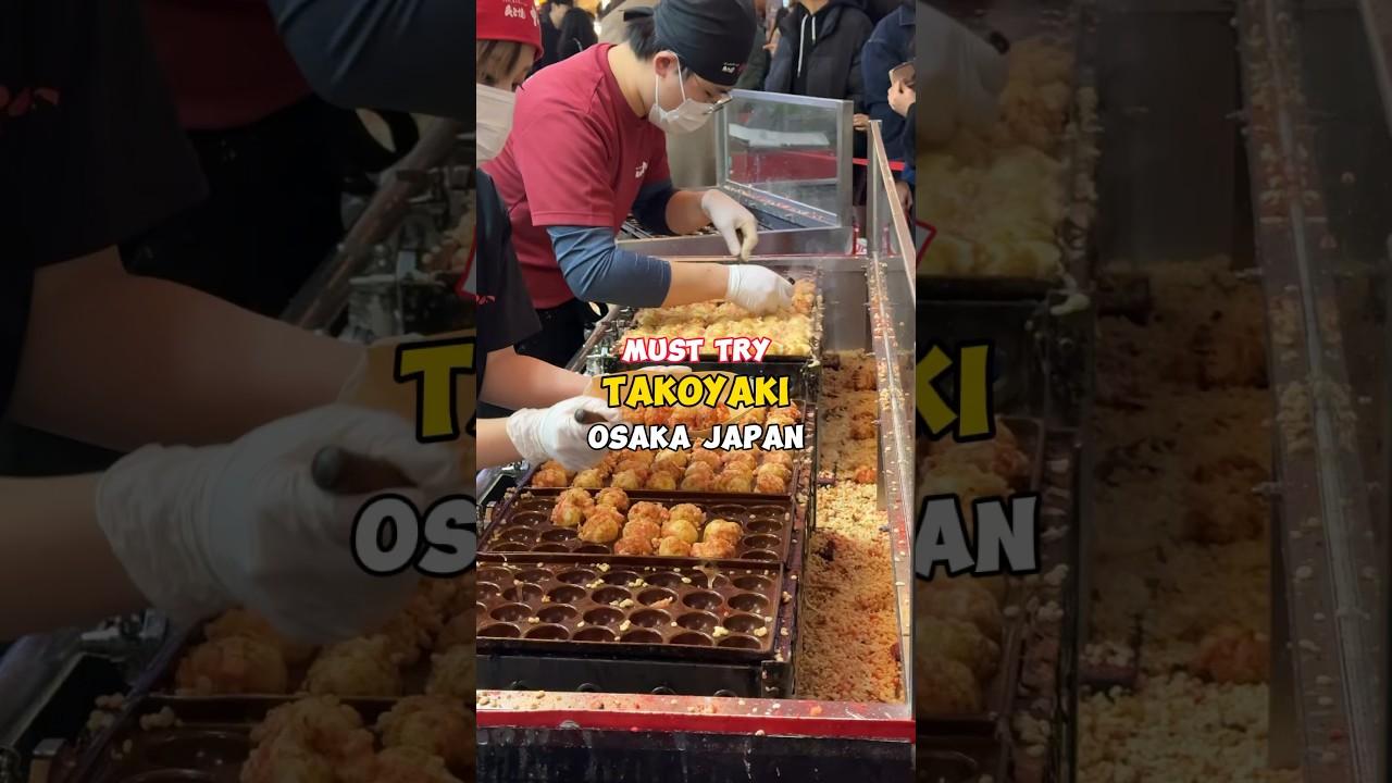 A street food vendor in Osaka, Japan, making takoyaki at a busy stall