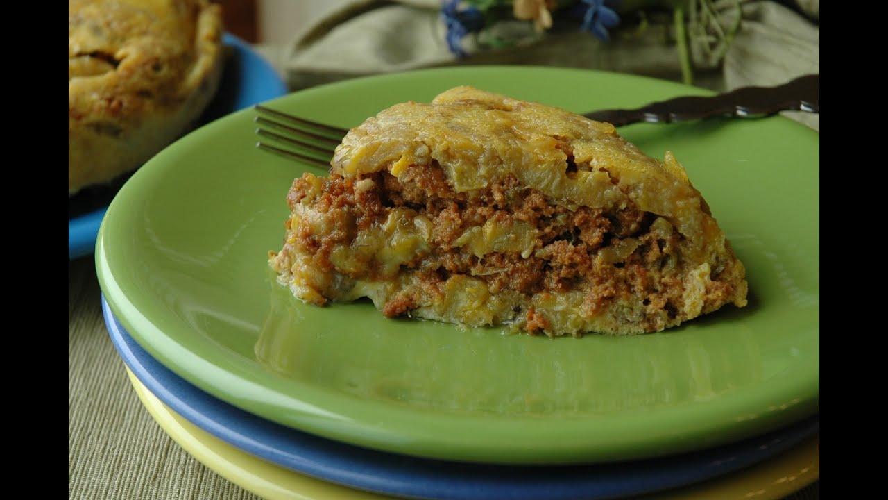 close-up shot of someone cutting a slice of plantain and pecan pie