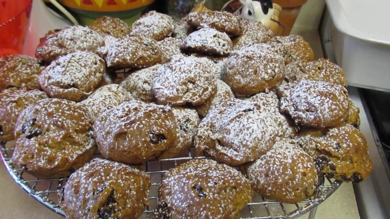 baker dusting zabaglione cookies with powdered sugar