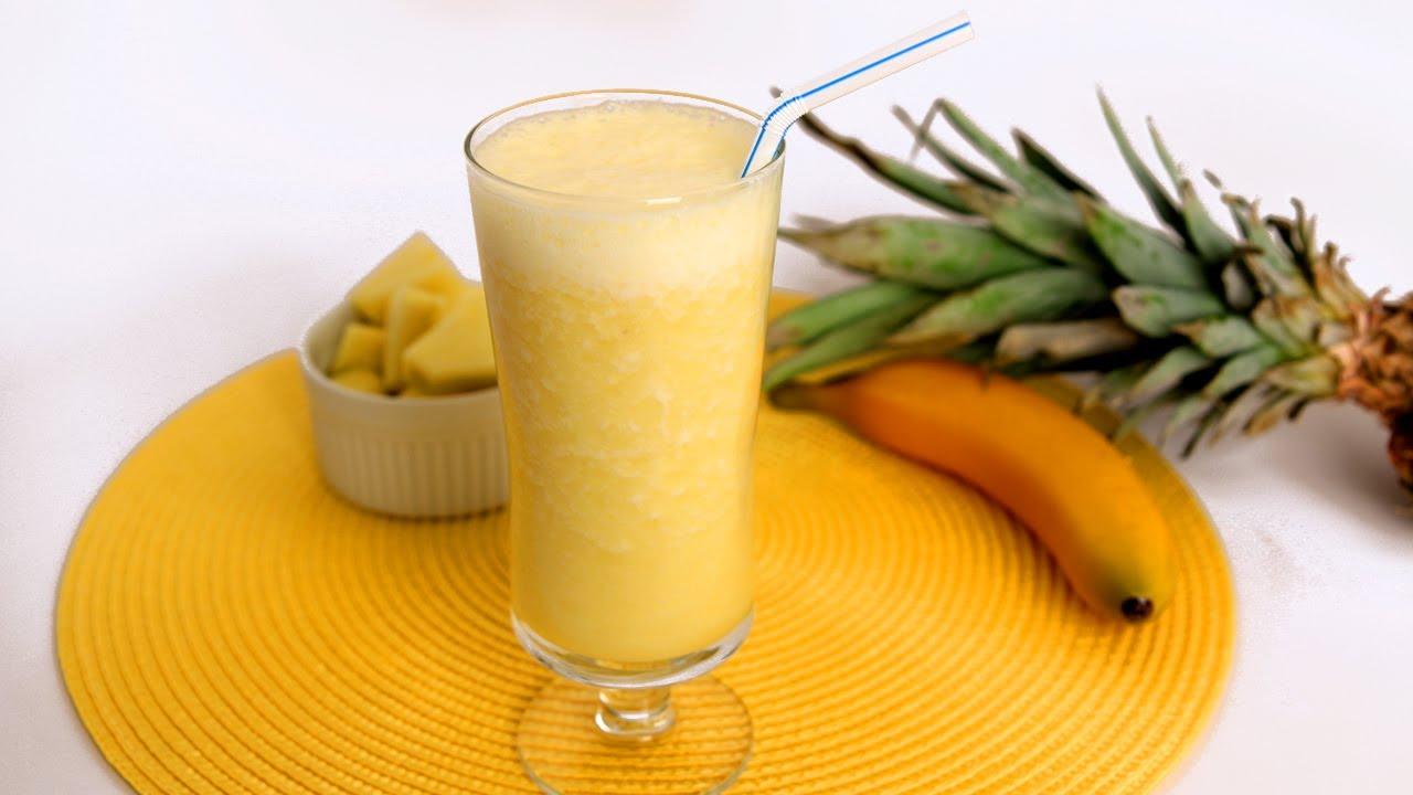 A person preparing ingredients for a smoothie, including Ugli fruit, banana, and pineapple