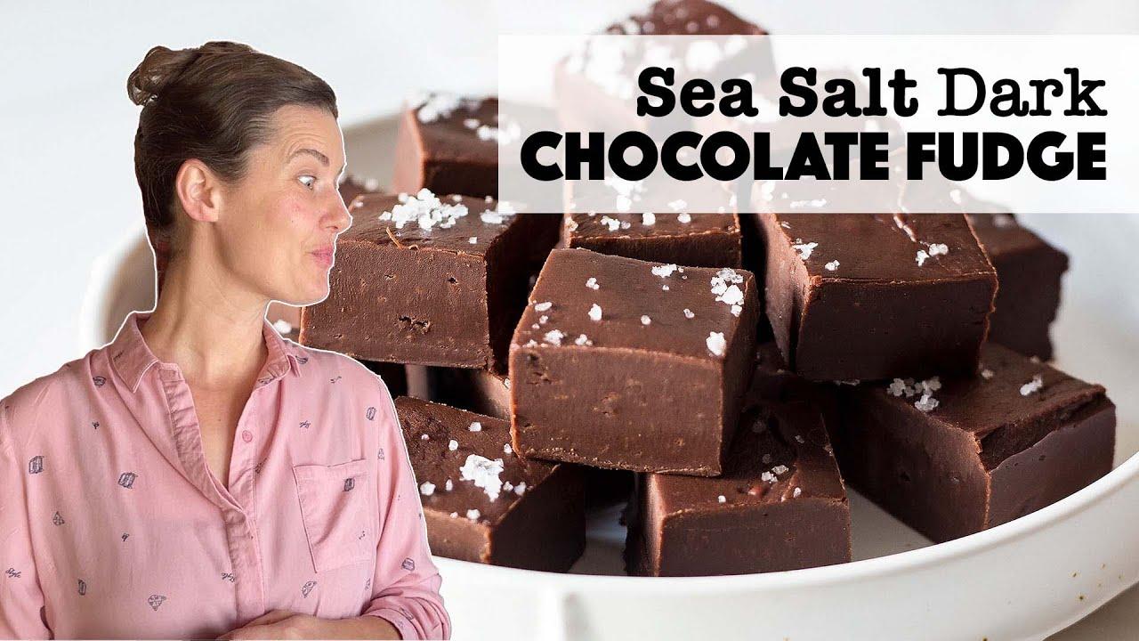 hands sprinkling sea salt on a pan of fudge