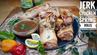 A close-up shot of someone dipping a Jerk Chicken Spring Roll into Tamarind Sauce