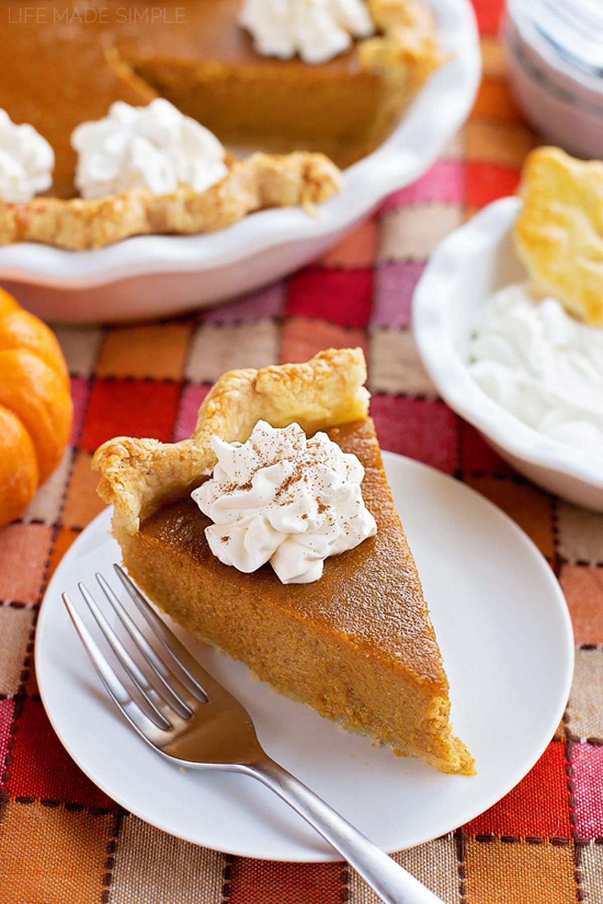 Pumpkin pie slice with a perfect homemade whipped cream swirl