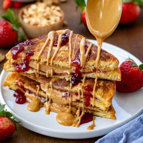 A plate of Peanut Butter Cup French Toast with syrup and a glass of orange juice