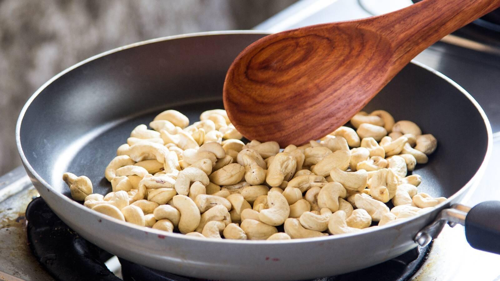 person roasting nuts in a pan