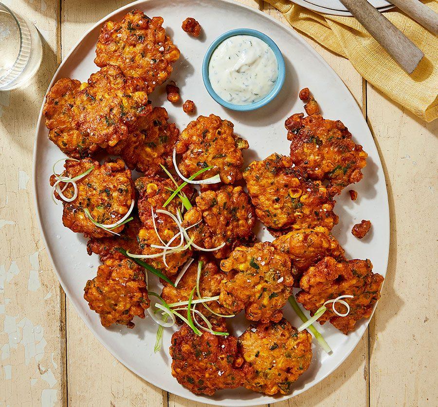 Golden brown Easter lamb and sweet corn fritters arranged on a platter