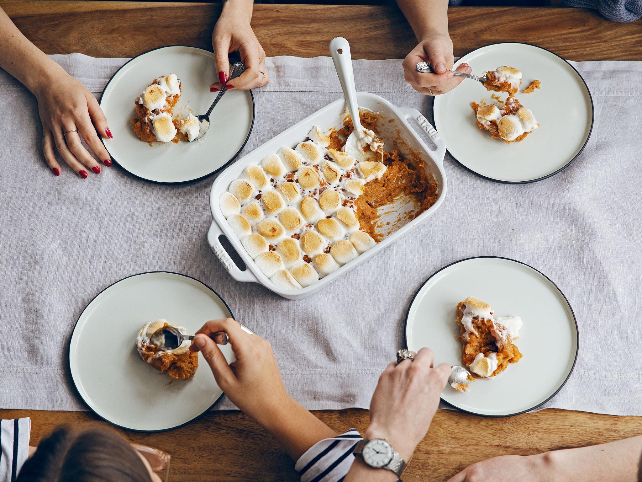 Vintage photo of a grandmother and grandchild smiling over a Thanksgiving table with a sweet potato casserole