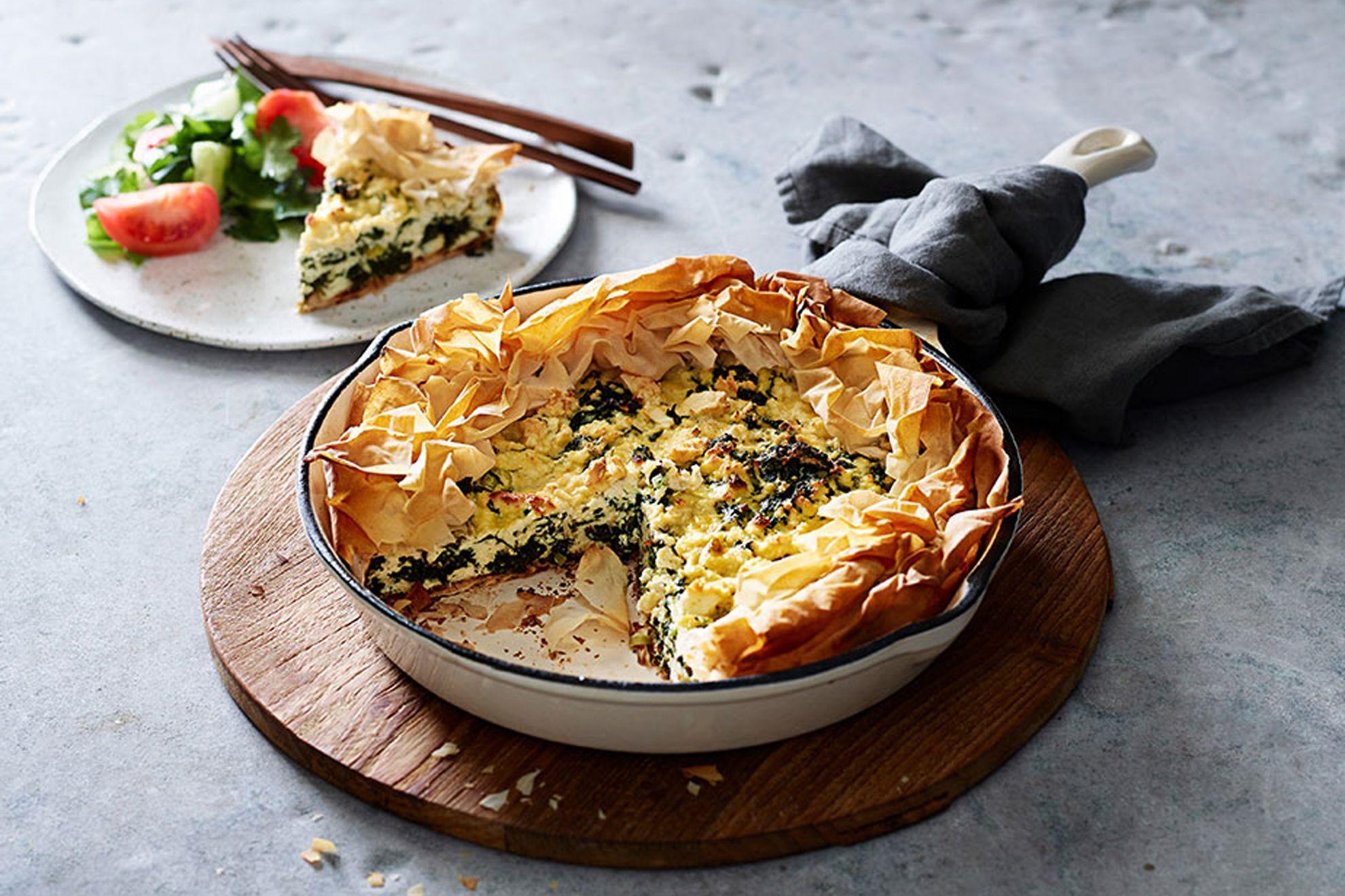 rustic wooden table with a bowl of spanakopita flakes