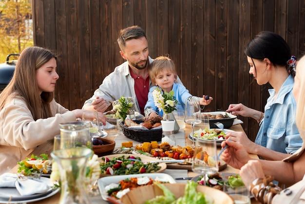 Close up of a family gathered around a table, enjoying the stew
