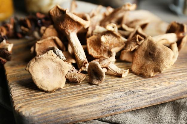 Close-up shot of uncooked wild mushrooms on a wooden cutting board