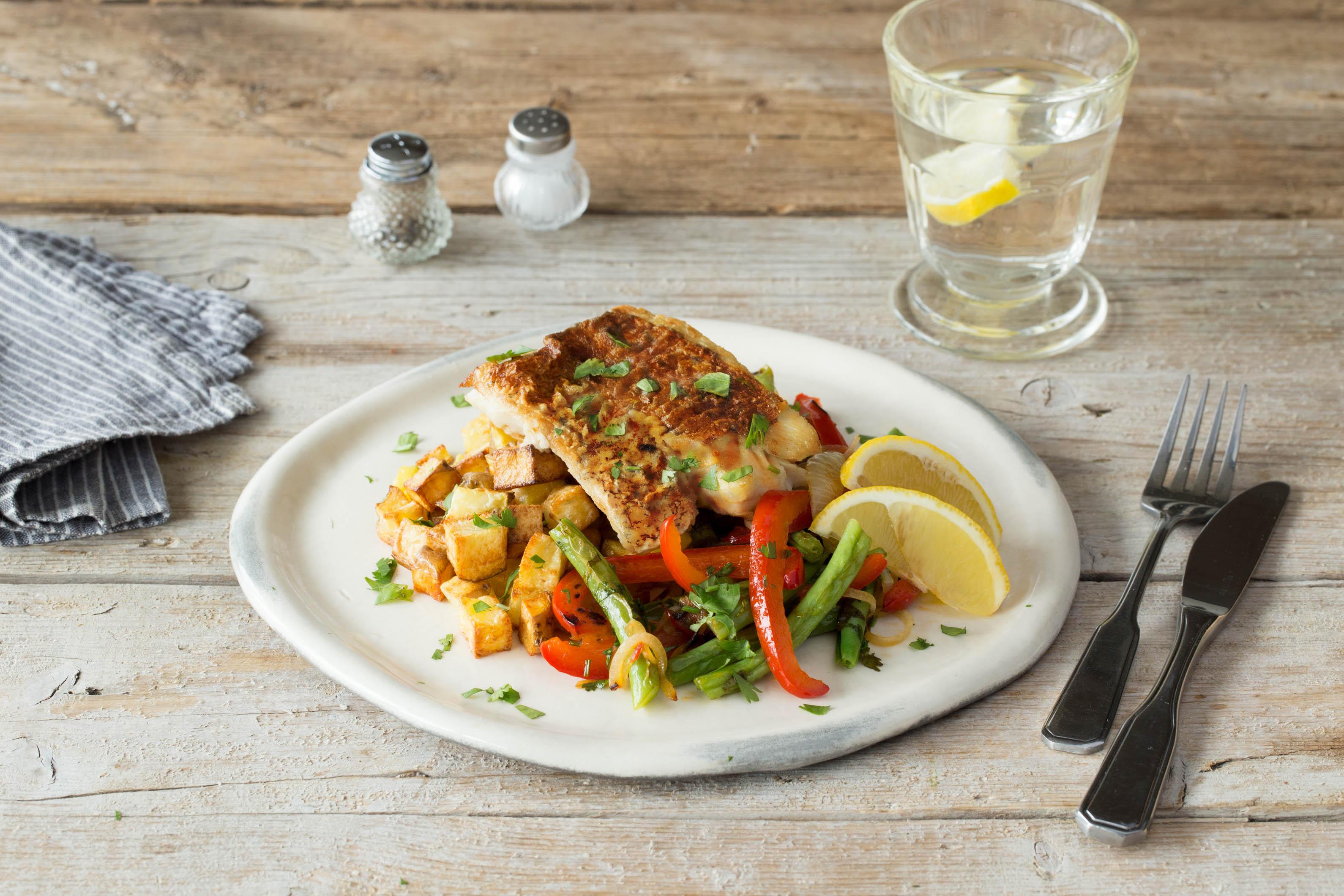 blackened sauteed catfish plated with vegetables