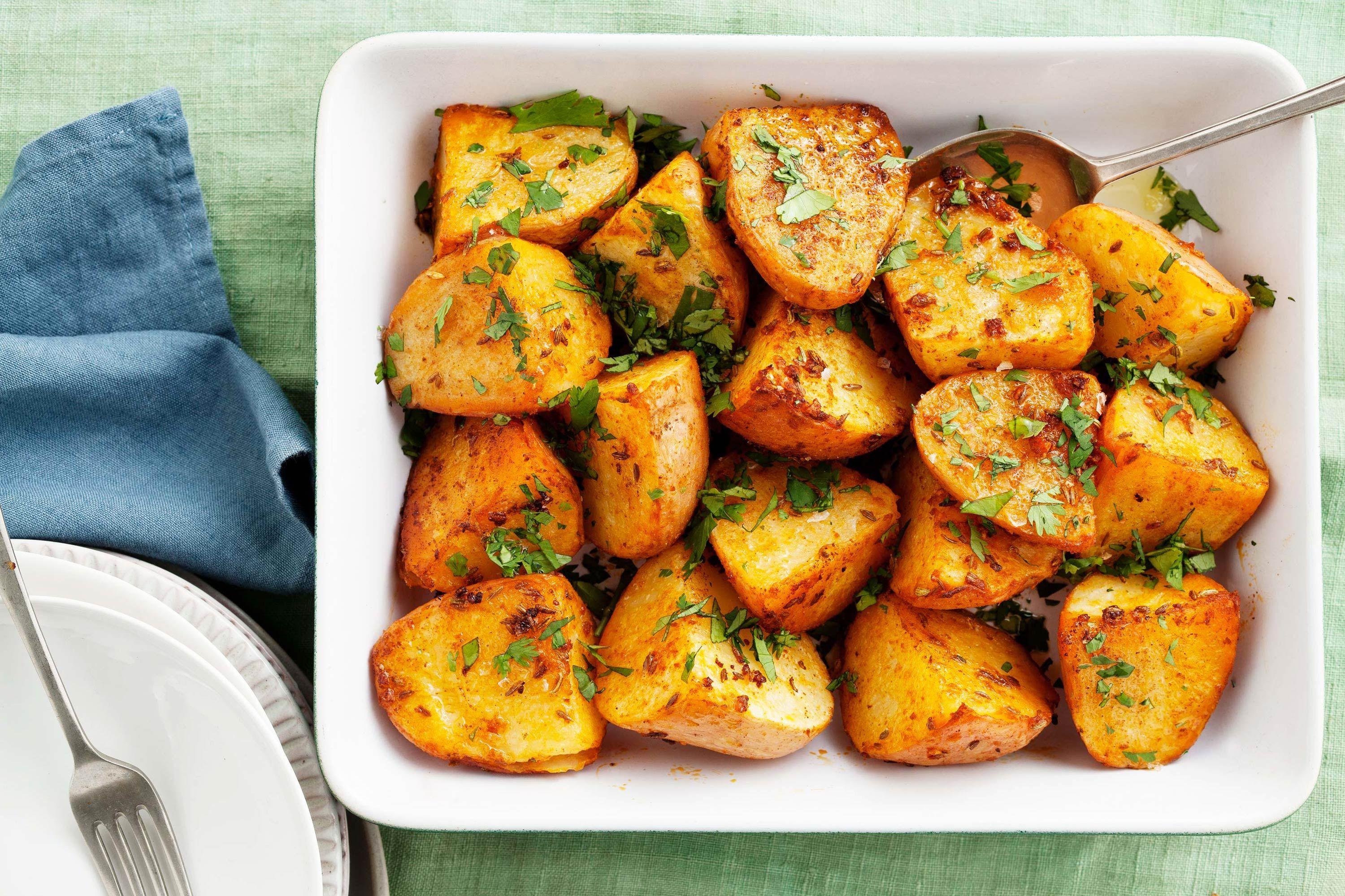 Close-up shot of golden-brown roasted potatoes seasoned with cumin and smoked paprika
