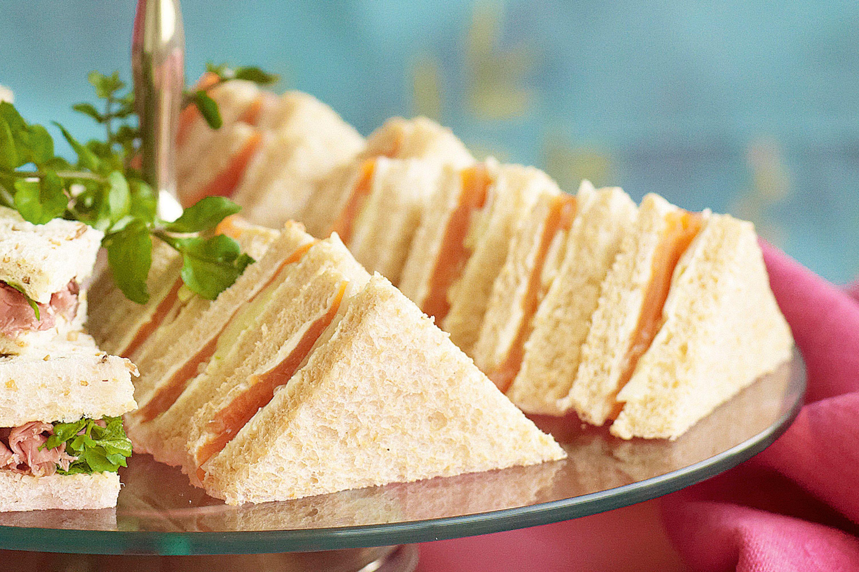 Close-up of a single smoked salmon and cucumber sandwich, showing the layers
