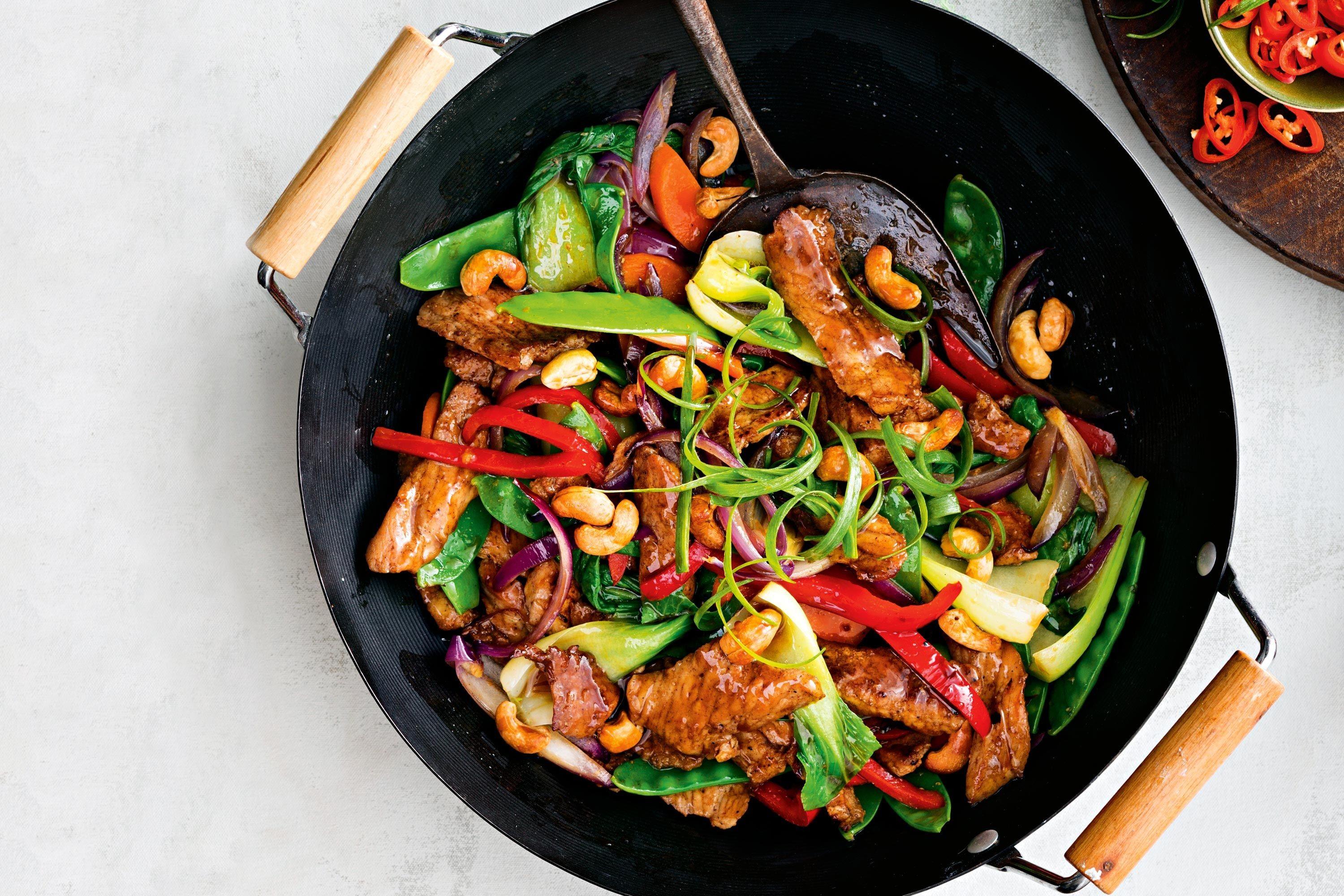 overhead shot of a wok filled with Visayan stir-fry ingredients, including pork, vegetables, and sauce
