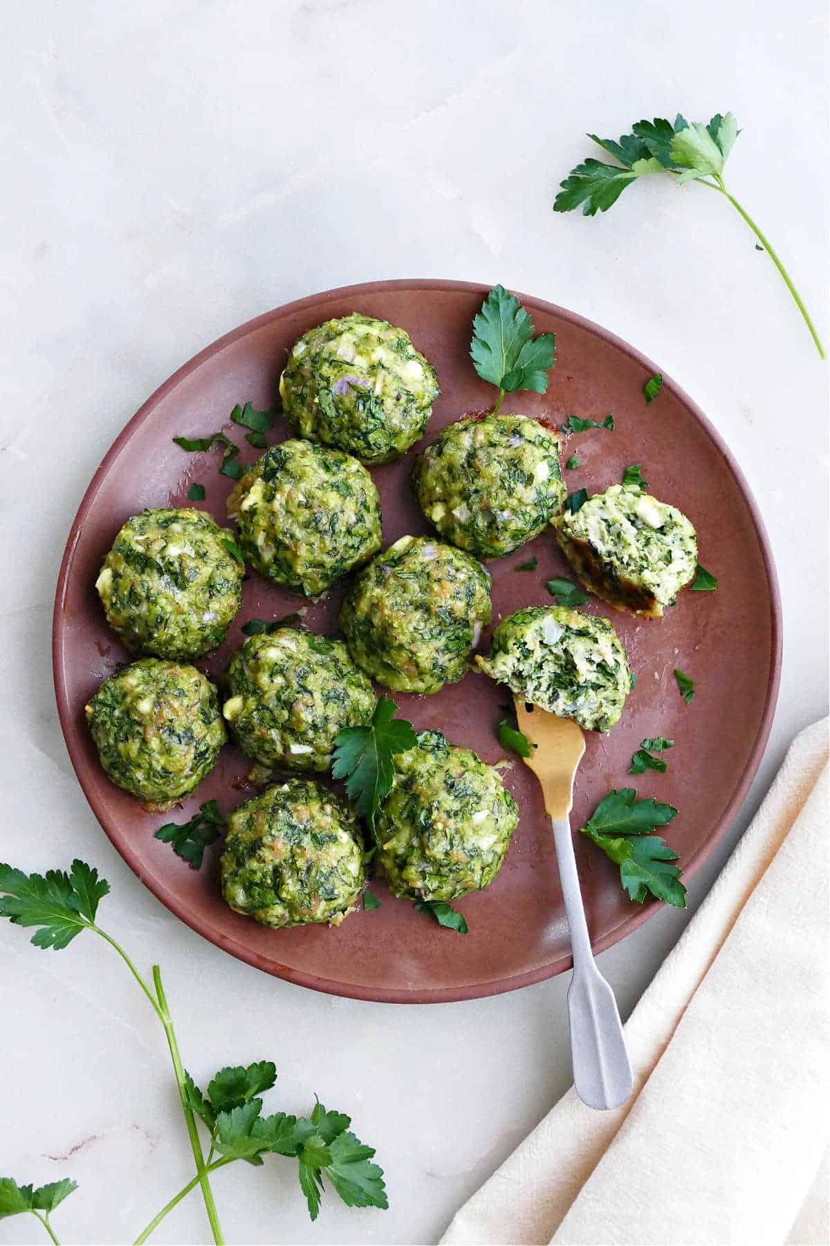 a top-down view of plant-based meatballs served over fresh spinach