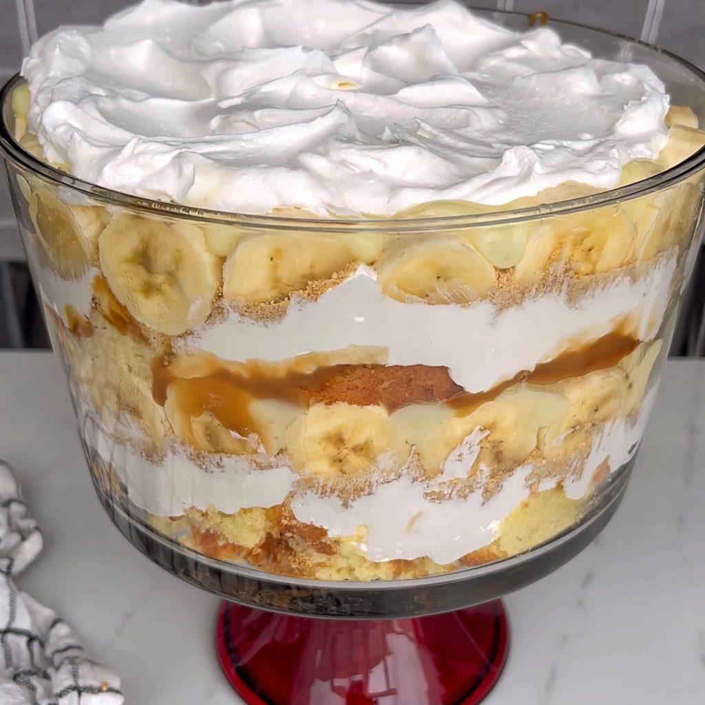 close-up shot of a banana slice being added to a layer of the trifle