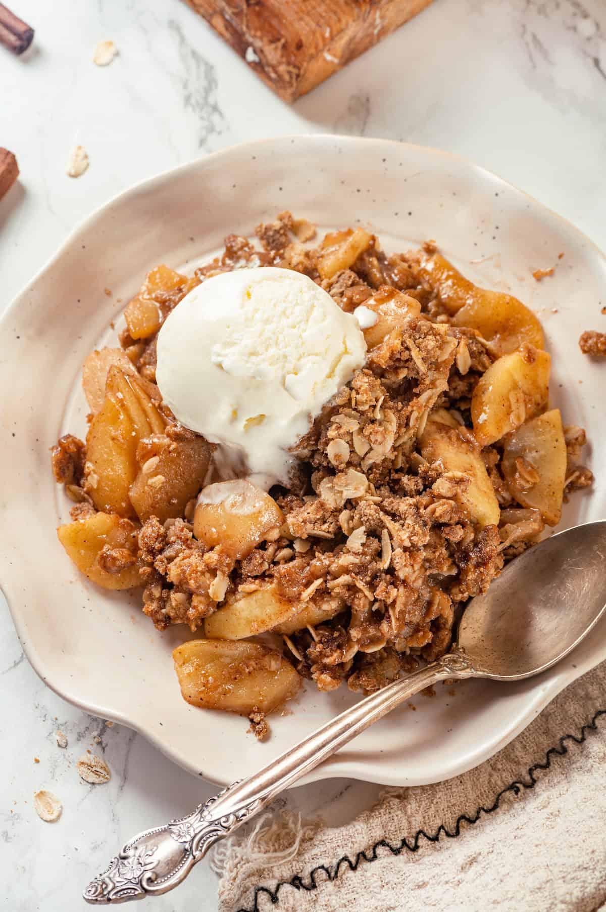 overhead shot of a warm walnut apple crisp with a scoop of vanilla ice cream