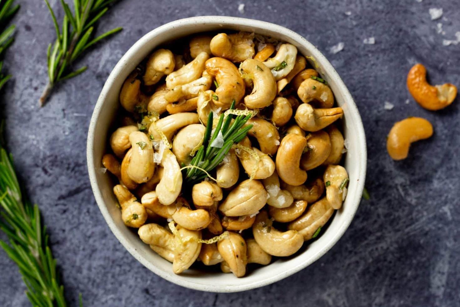 close up of lemon garlic roasted cashews on a white plate
