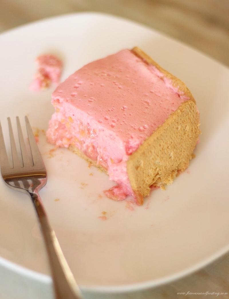 A slice of guava cream tart on a plate next to fresh guavas