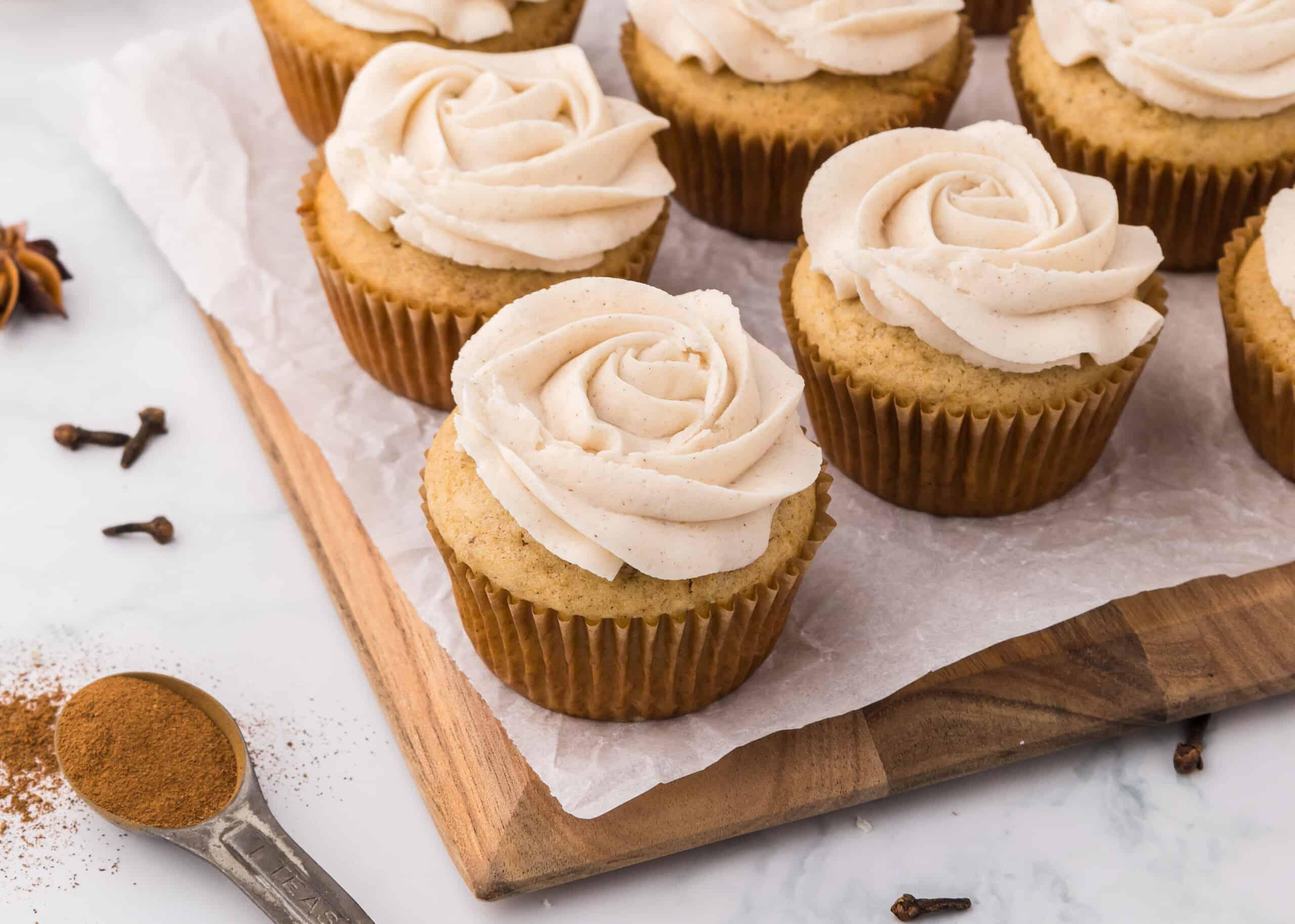 overhead shot of freshly baked apple spice latte cupcakes arranged on a wooden board
