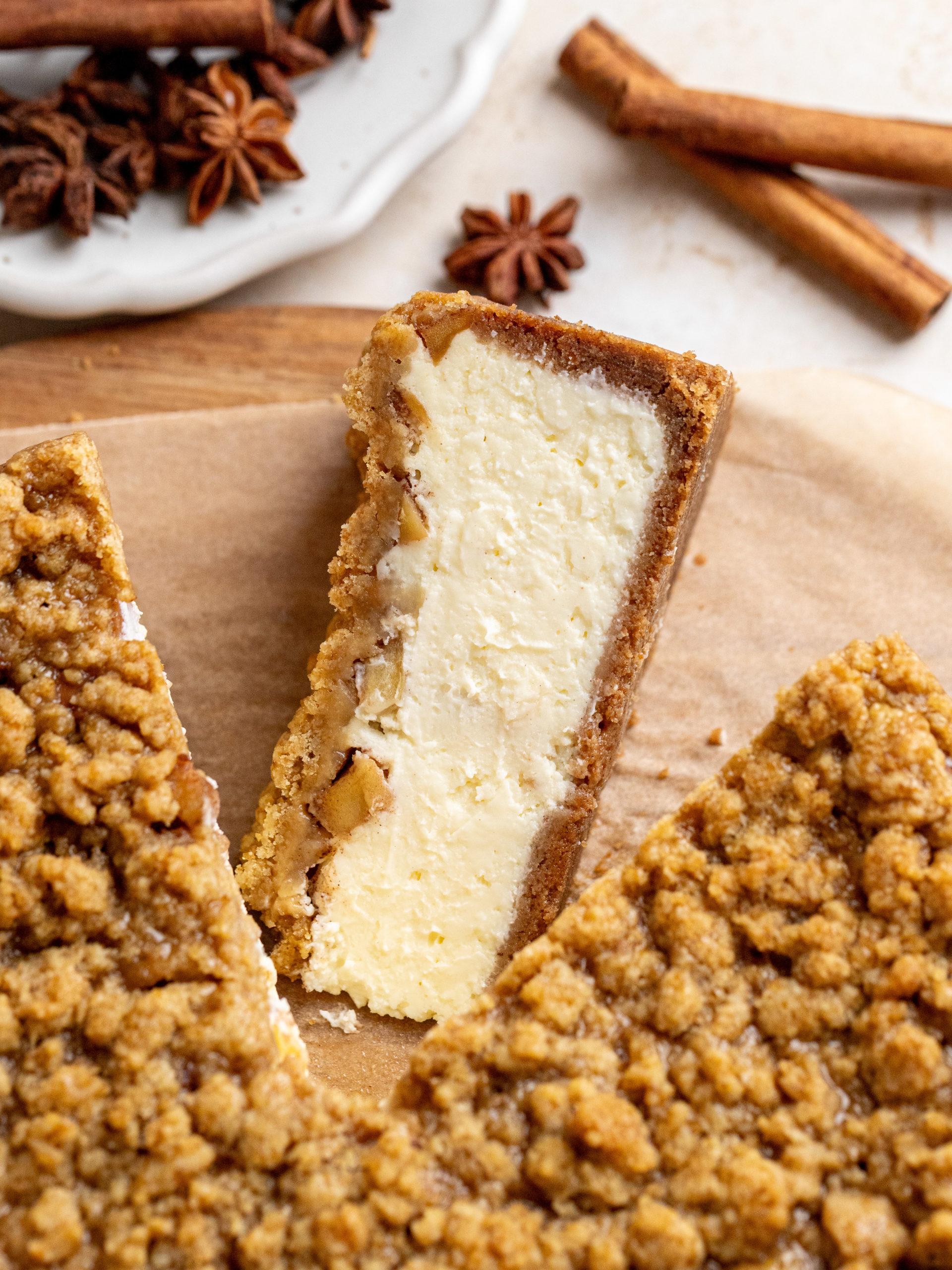 slice of apple crumble cheesecake with cinnamon sticks