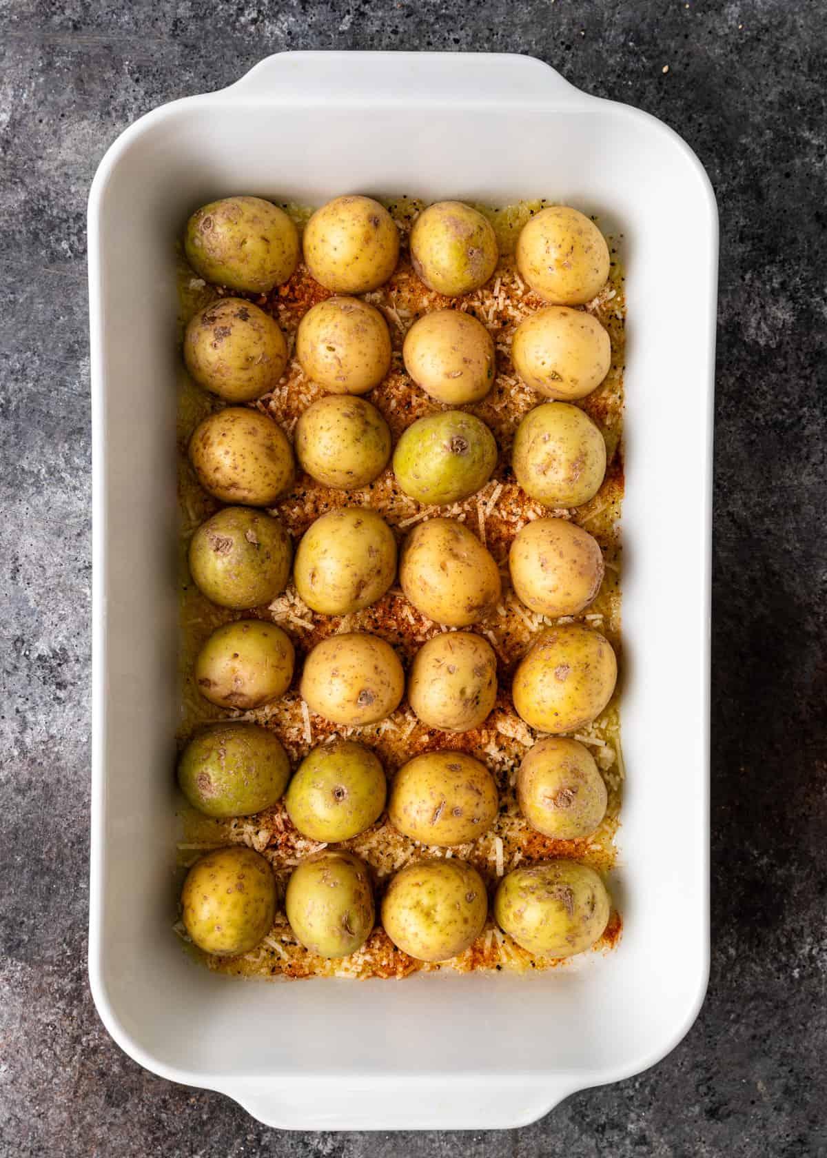 Overhead shot of parmesan roasted potatoes baking on a sheet pan in the oven