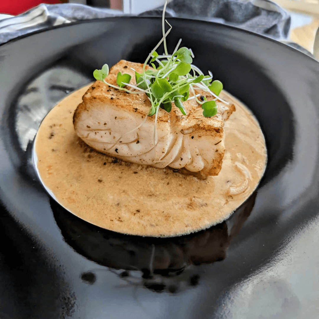 finished baked halibut with garlic butter sauce on a plate