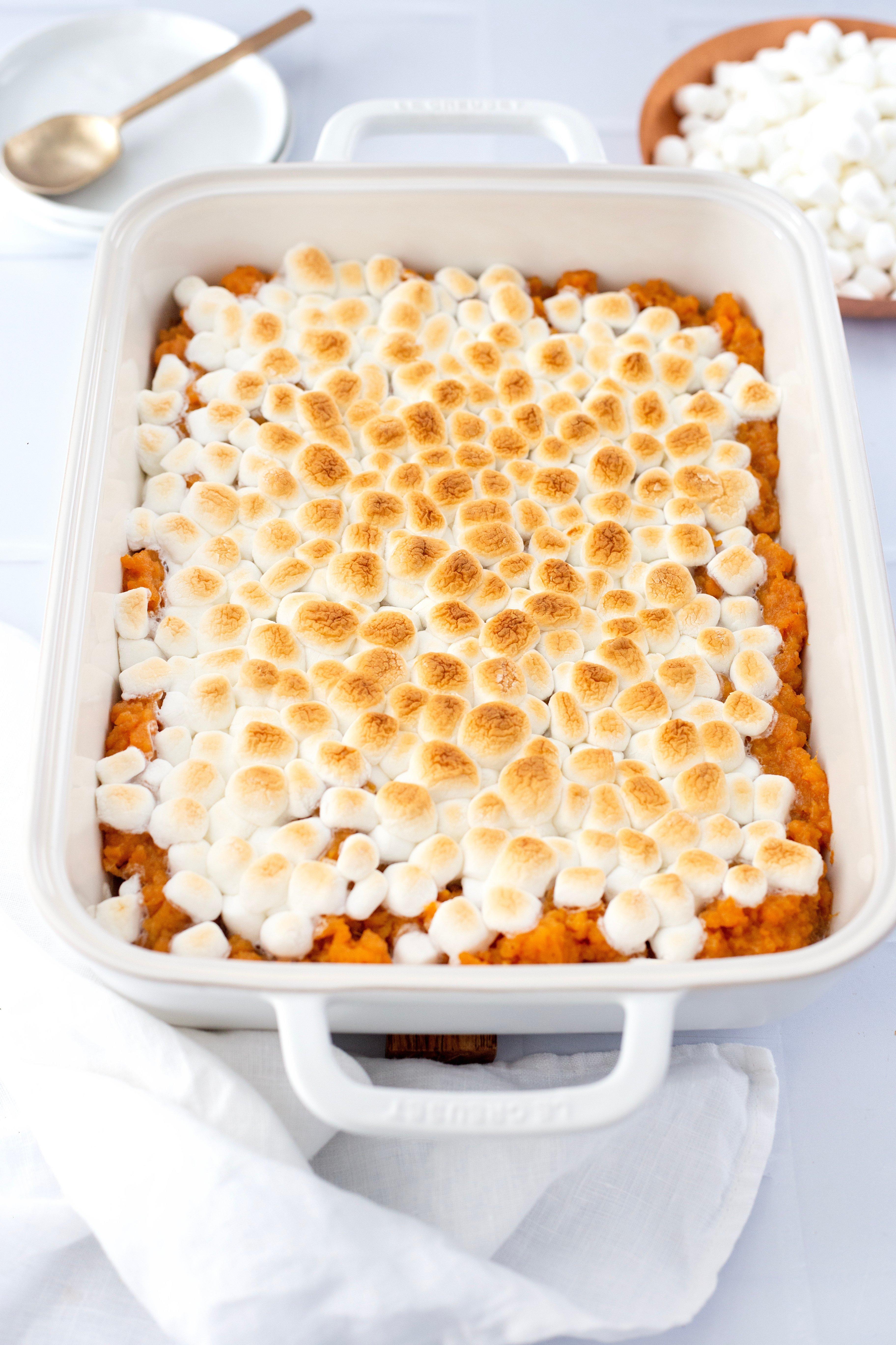 Cozy Thanksgiving dinner table, sweet potato casserole with marshmallows as centerpiece