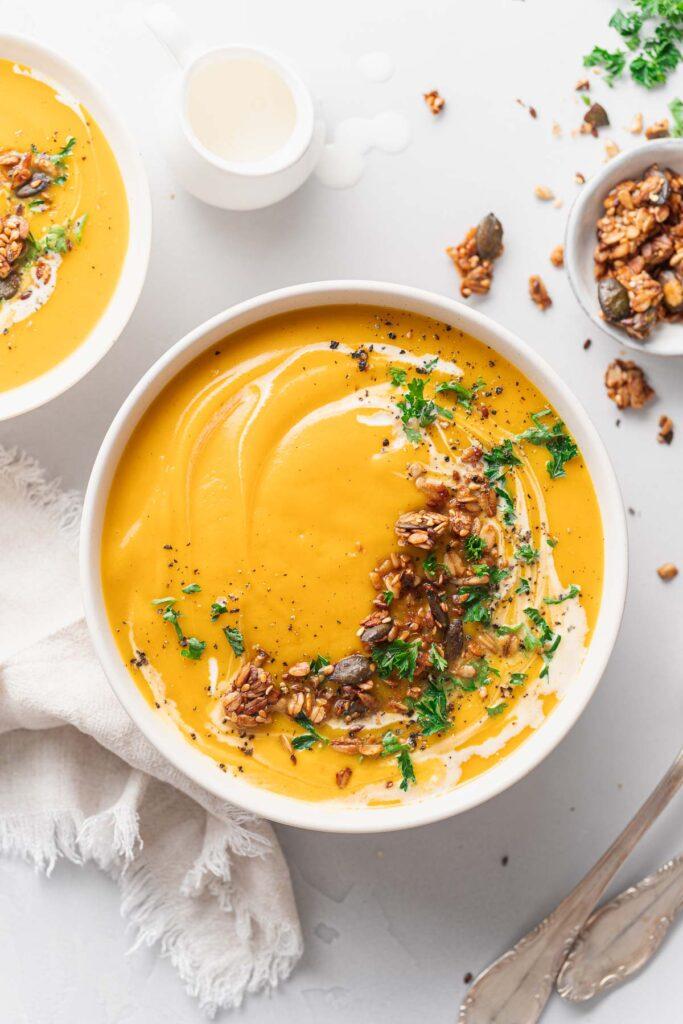 creamy pumpkin and butternut squash soup in a bowl with garnish