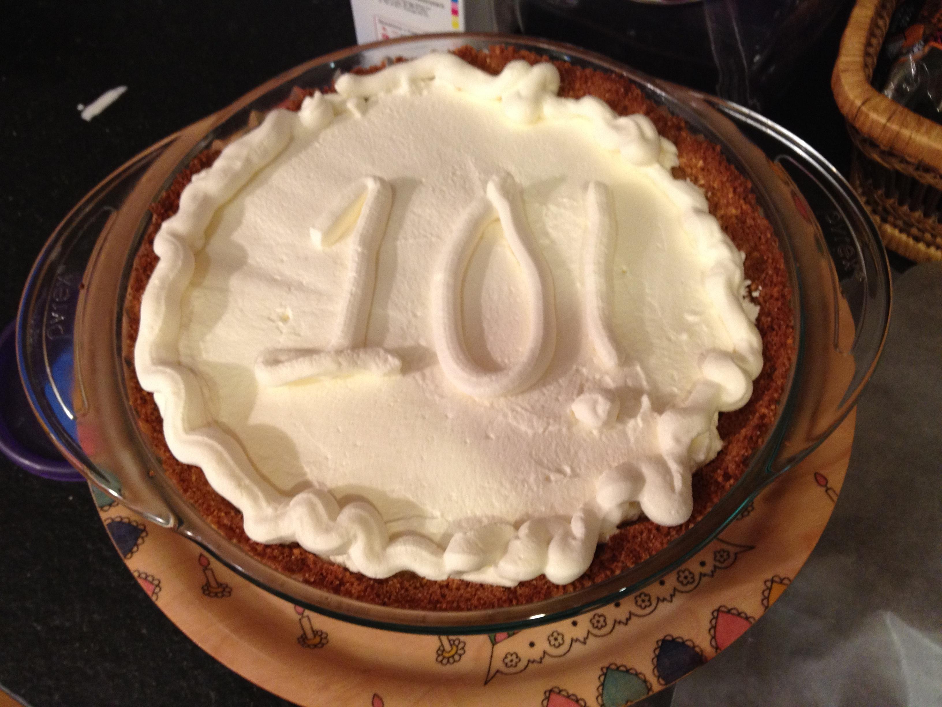 overhead shot of a whole key lime birthday pie cake with candles