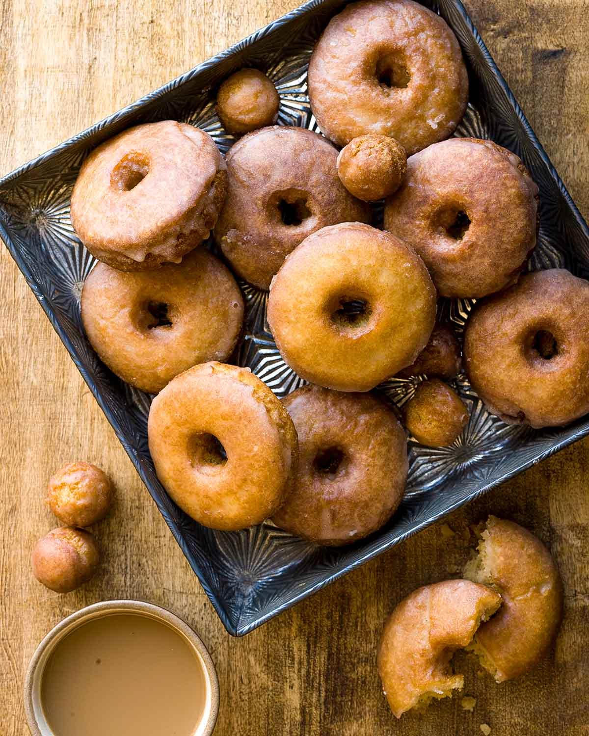 close-up of spiced apple cider donuts being glazed