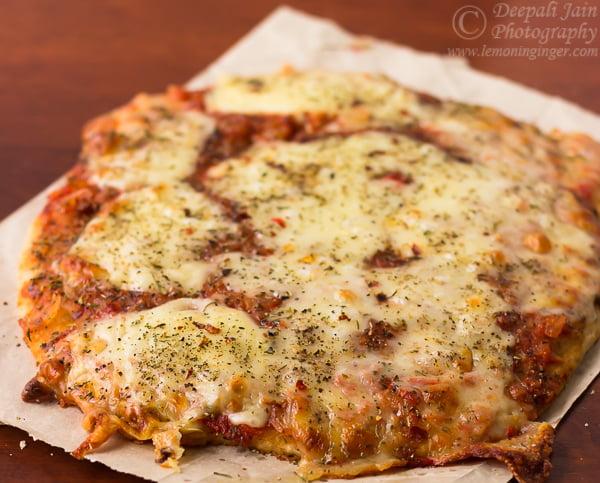 close-up shot of a freshly baked wheat flour pizza topped with fresh basil