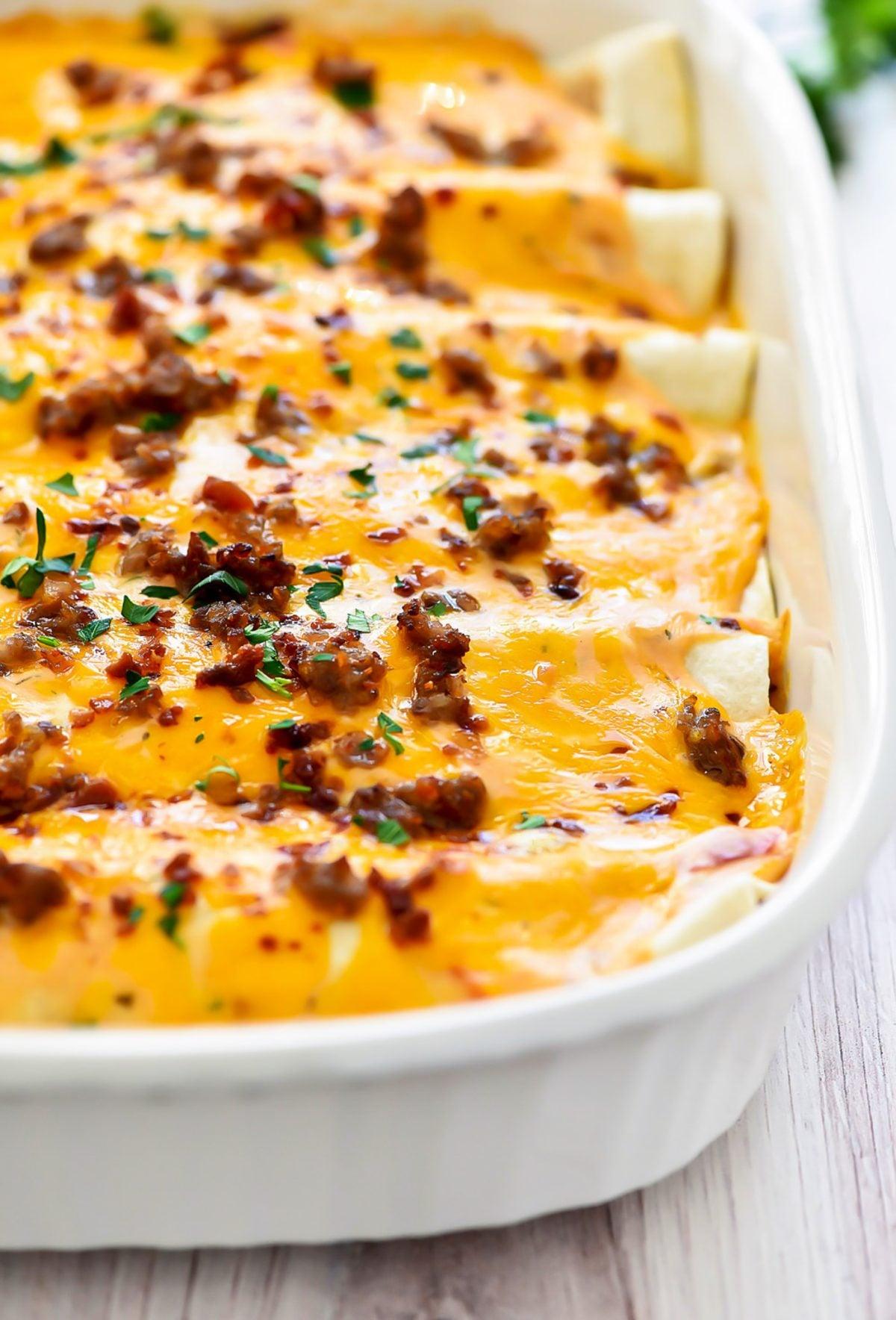 Close-up of golden brown breakfast enchiladas with visible eggs and cheese