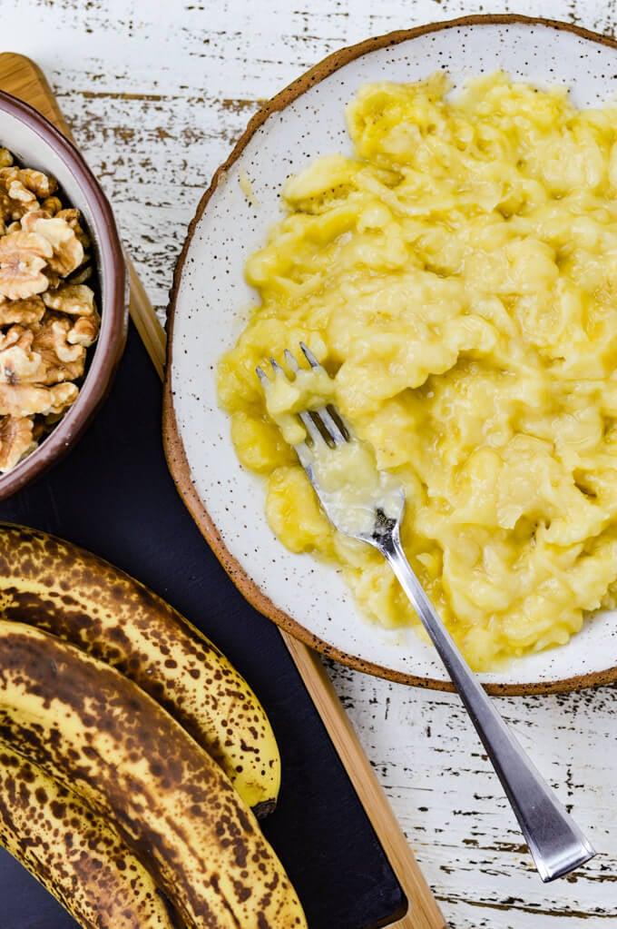 Bowl of mashed ripe bananas with walnuts and flour