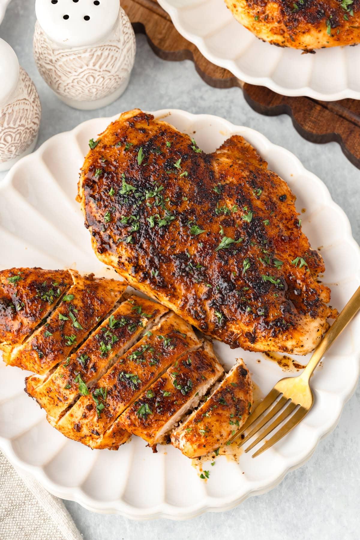 Home cook happily plating a golden-brown butter pan chicken breast