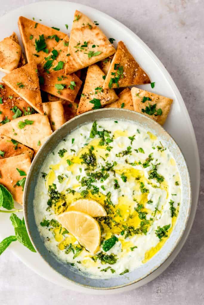 fresh tzatziki sauce in a bowl with cucumbers and pita bread
