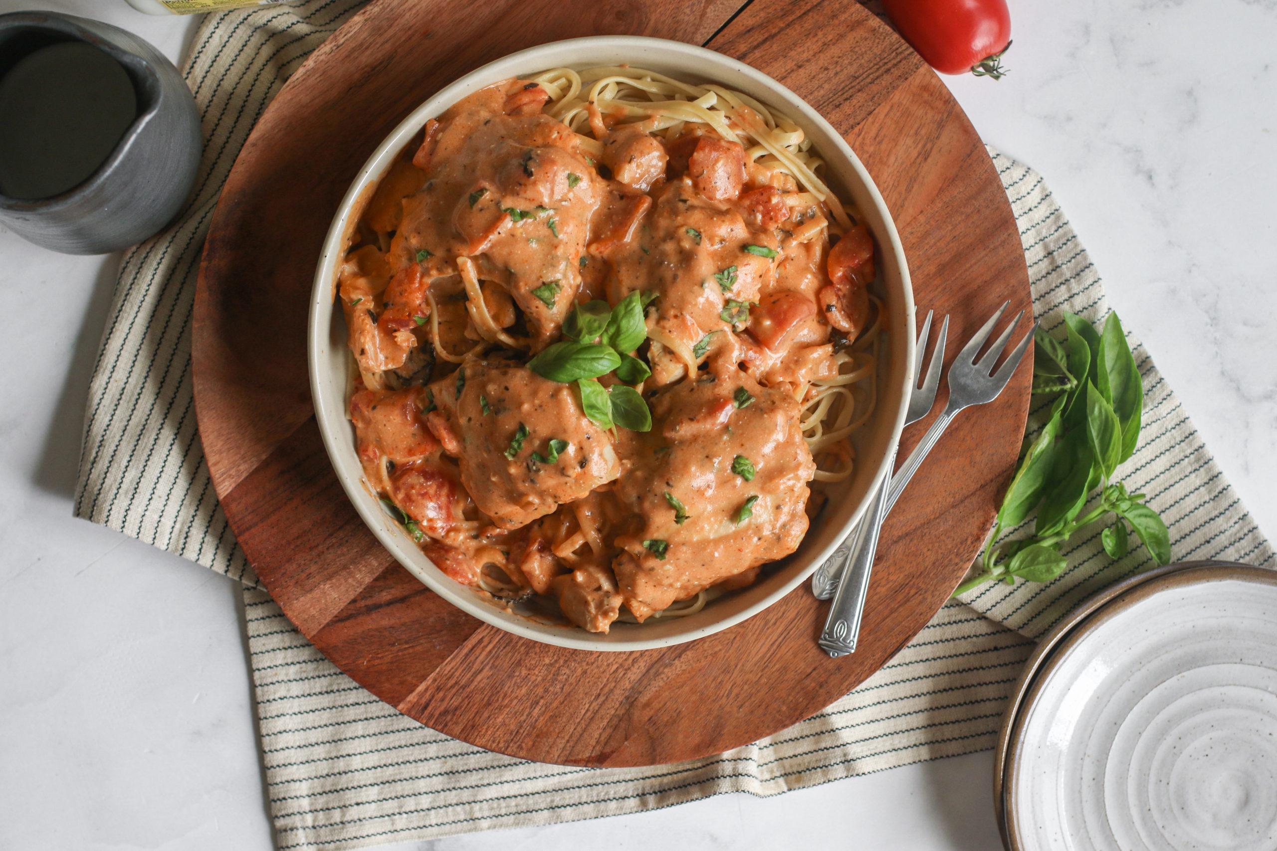 Close-up of creamy tomato chicken in a slow cooker, simmering
