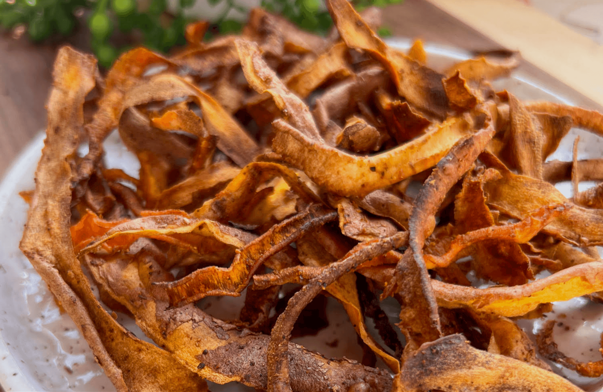 crispy vegetable peel chips on a wooden board, salt and vinegar seasoning, beet peel spirals