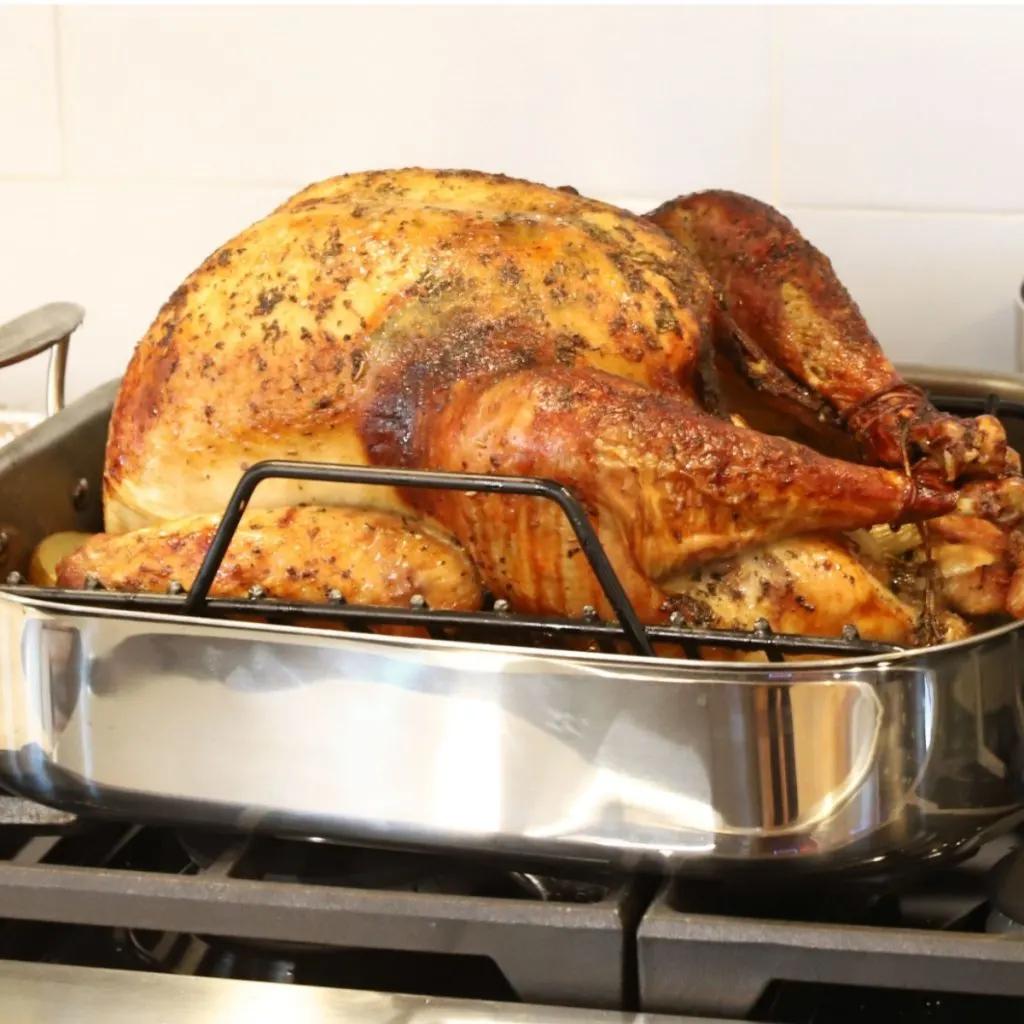 rustic kitchen scene with a seasoned, unbaked turkey ready for the oven