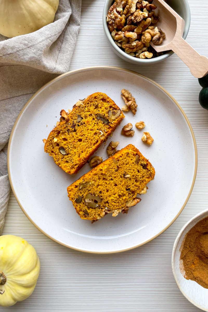 slices of homemade pumpkin bread with nuts and a cup of coffee