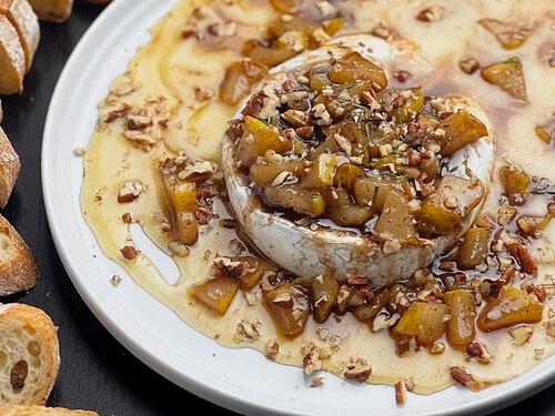 Thanksgiving brie honey tart on a rustic wooden board with festive garnishes